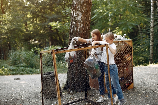 I bambini raccolgono immondizia nei sacchetti di immondizia nel parco