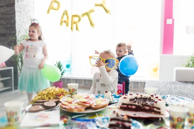 I bambini si avvicinano al tavolo per la festa di compleanno