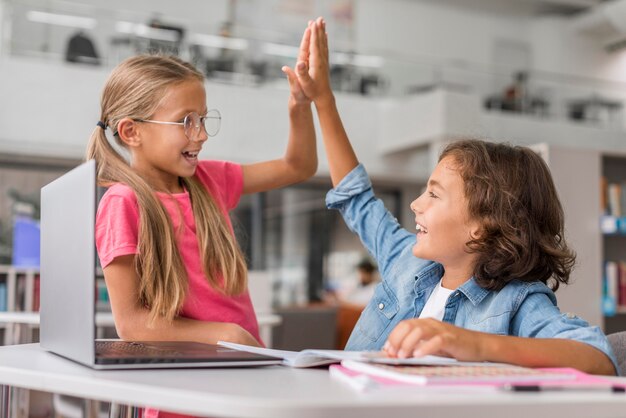 I bambini si danno il cinque in biblioteca