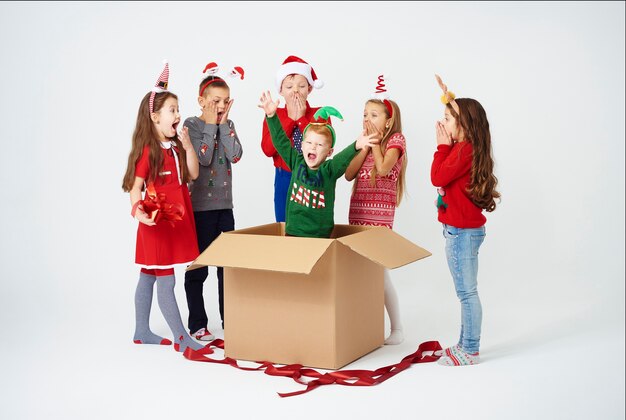 I bambini sono sorpresi durante l'apertura del regalo di Natale