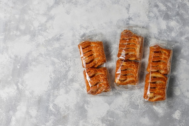 I biscotti della pasta sfoglia hanno riempito di marmellata di mele e mele rosse fresche su calcestruzzo leggero