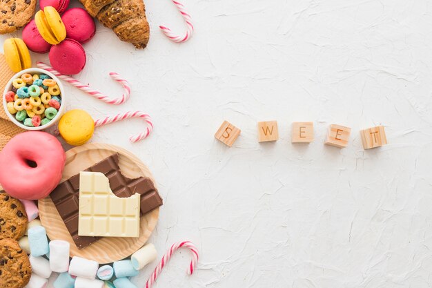 I blocchi cubici dolci si avvicinano all&#39;alimento non sano sul contesto bianco