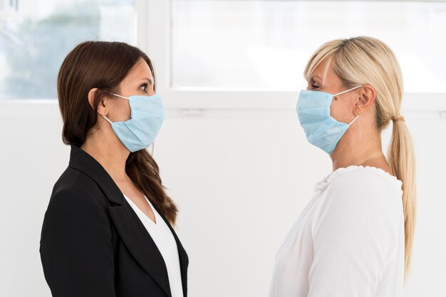 I colleghi che indossano la maschera di protezione al lavoro