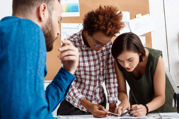 I colleghi sorridono, parlano, discutono di disegni, nuove idee in ufficio