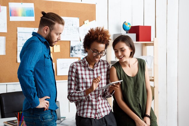 I colleghi sorridono, parlano, discutono di nuove idee in ufficio