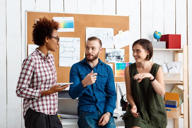 I colleghi sorridono, parlano, discutono di nuove idee in ufficio