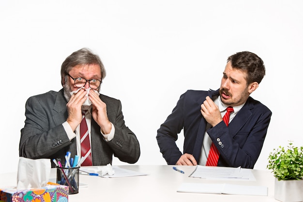 I due colleghi che lavorano insieme in ufficio su sfondo bianco.