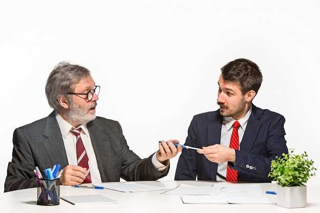 I due colleghi che lavorano insieme in ufficio su studio bianco