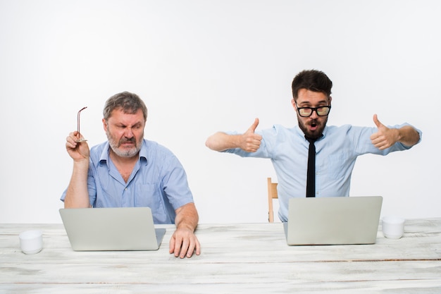 I due colleghi che lavorano insieme in ufficio sul muro bianco