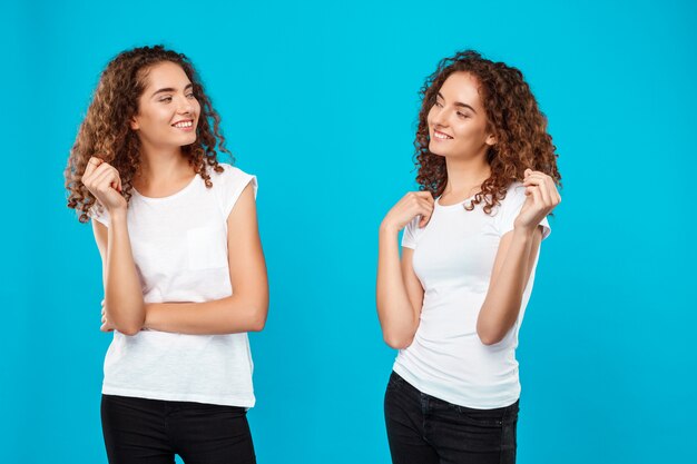 I gemelli di due womans che si guardano sopra l'azzurro.