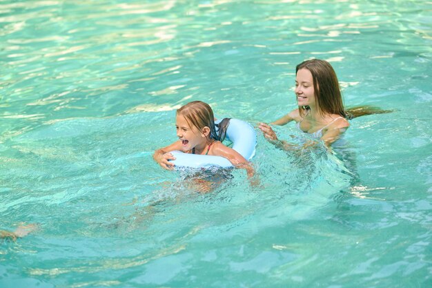 I genitori insegnano alla figlia a nuotare e sembrano coinvolti