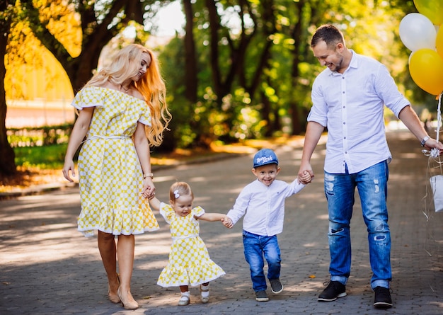 I genitori stupendi si divertono con i loro due bambini che passeggiano nel parco