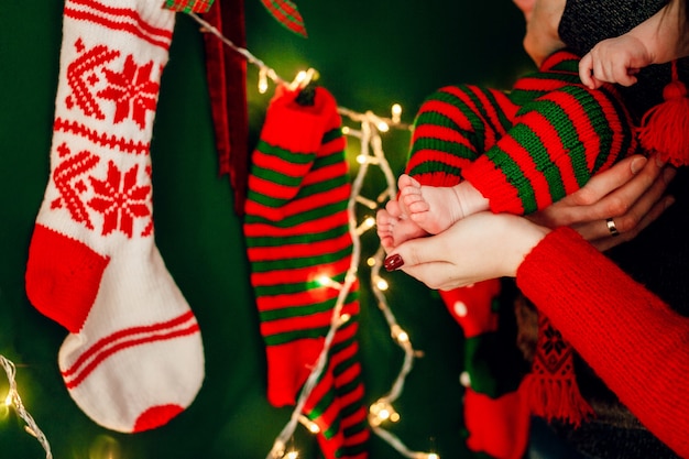 I genitori tengono i piedi dei bambini davanti a una ghirlanda luminosa