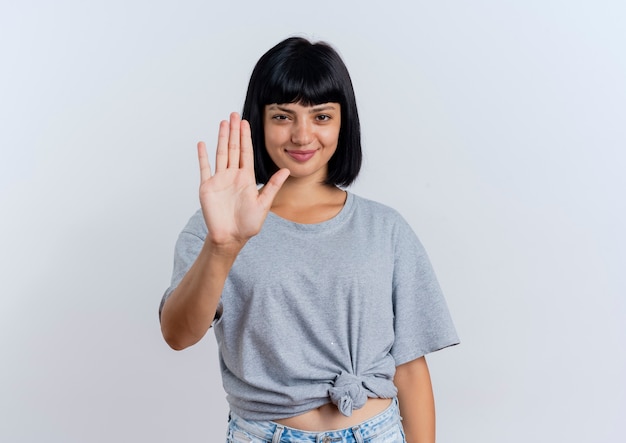I gesti della giovane donna caucasica castana compiaciuta fermano il segno della mano