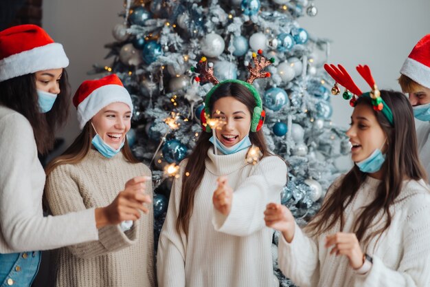 I giovani che celebrano il capodanno tenendo le stelle filanti, amici multirazziali che si divertono alla celebrazione della festa