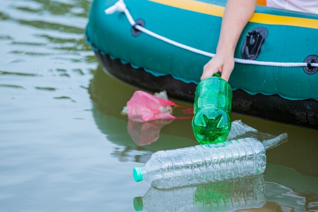 I giovani raccolgono la spazzatura nel fiume, il concetto della Giornata nazionale della gioventù e la Giornata mondiale dell'ambiente.