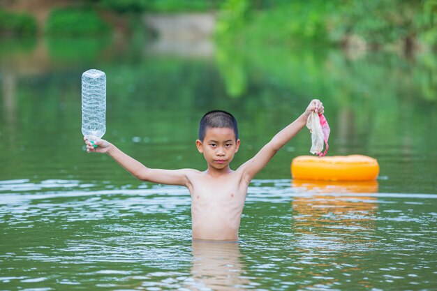 I giovani raccolgono la spazzatura nel fiume, il concetto della Giornata nazionale della gioventù e la Giornata mondiale dell'ambiente.