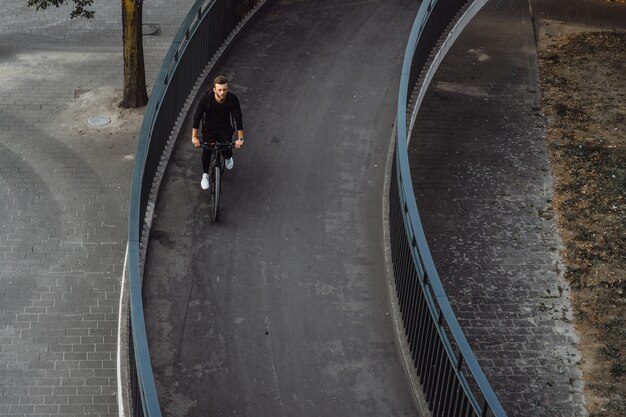 I giovani sport equipaggiano su una bicicletta in una città europea. Sport in ambienti urbani.
