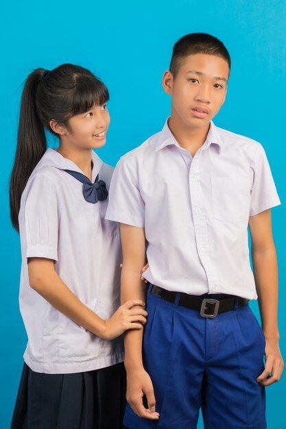 I giovani studenti asiatici e gli studenti maschi asiatici stanno insieme su un blu.
