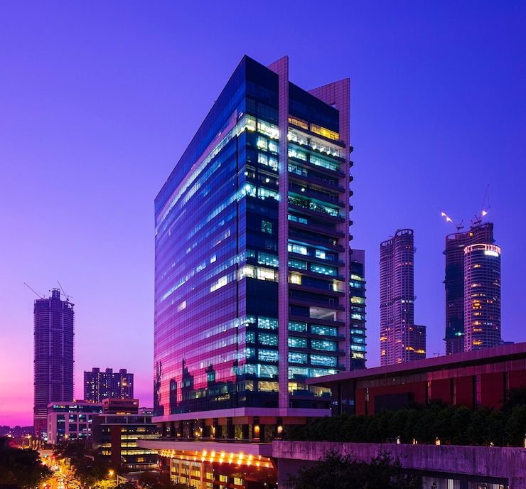 Foto gratuito i grattacieli rivestiti di vetro del centro di mumbai riflettono le sfumature del tramonto all'ora blu