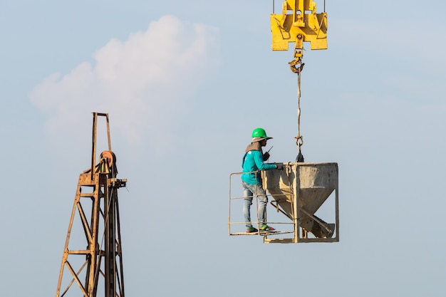 I lavoratori lavorano sulla gru in cantiere