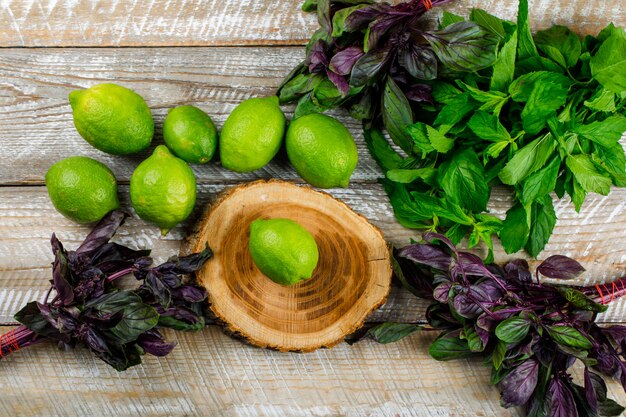 I limoni con basilico lascia sul tagliere di legno e, disposizione piana.