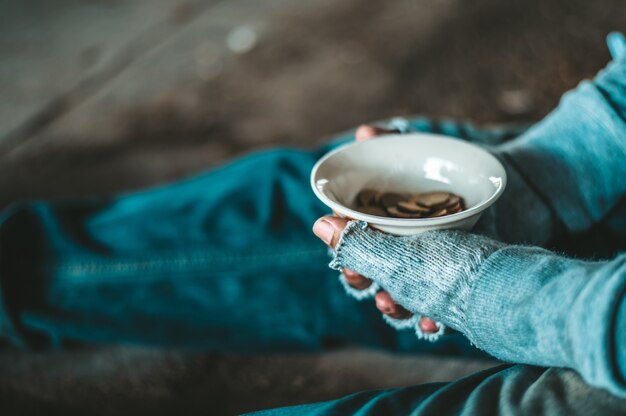 I mendicanti seduti sotto un ponte con le tazze hanno soldi.