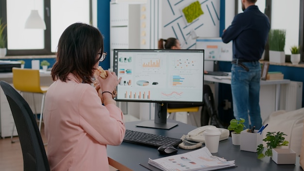 I rack si concentrano sugli uomini d'affari che lavorano alle statistiche finanziarie durante la pausa pranzo durante l'ora di pranzo da asporto