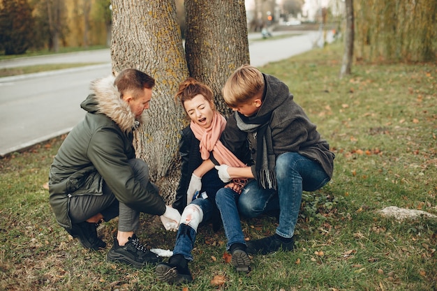 I ragazzi aiutano una donna. Ragazza con una gamba rotta. Fornire il primo soccorso nel parco.