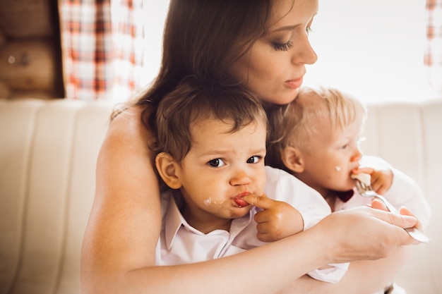 I ragazzini si siedono sulle braccia della madre