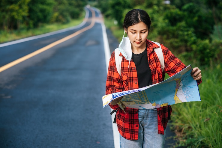 Foto gratuito i turisti femminili stanno e guardano la mappa sulla strada.