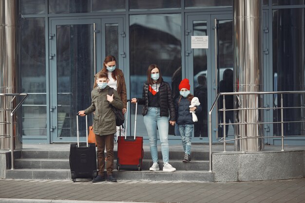 I viaggiatori che lasciano l'aeroporto indossano maschere protettive