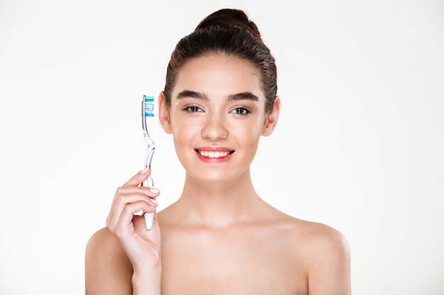 Igiene dentale e cura del corpo della donna graziosa in buona salute che posa con lo spazzolino da denti