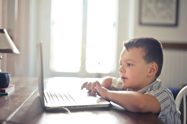 Il bambino usa un laptop a casa