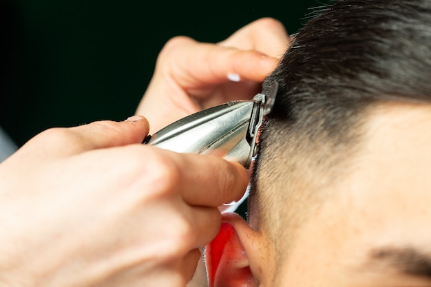 Il barbiere fa il taglio di capelli con la tagliatrice