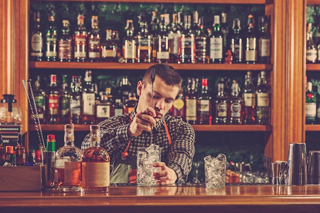 Il barista prepara un cocktail alcolico al bancone del bar nello spazio del bar