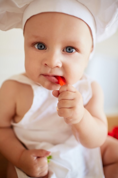 Il bel bambino mangia una carta rossa