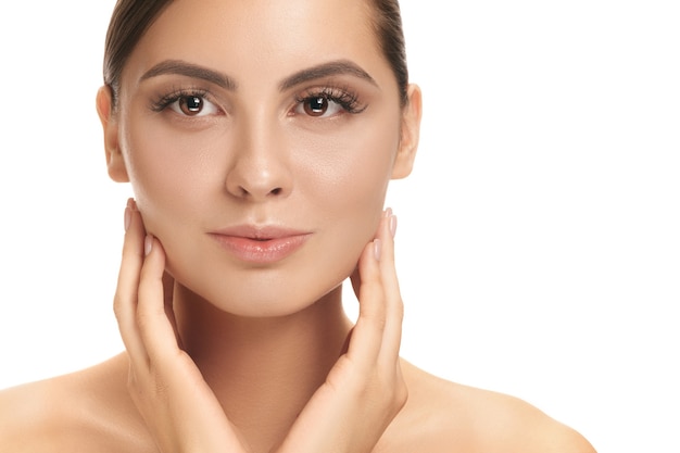 Il bel volto femminile. La pelle del viso perfetta e pulita sul muro bianco. La bellezza, cura, pelle, trattamento, salute, spa, concetto cosmetico