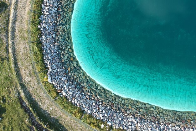 Il bello chiaro lago blu in un campo verde ha sparato da sopra