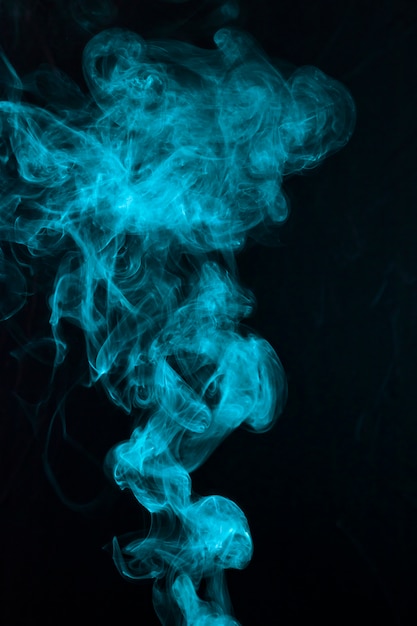 Il bello modello blu del fumo si è sparso sul contesto nero