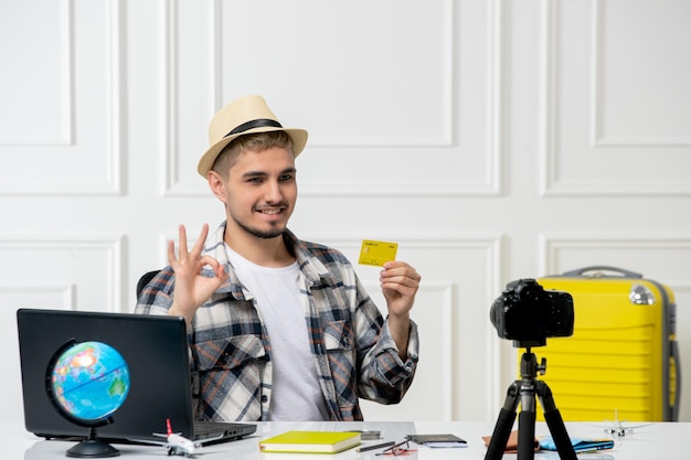 Il blogger di viaggio registra il vlog di viaggio sulla fotocamera giovane bel ragazzo con cappello di paglia molto felice