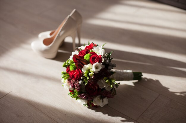 Il bouquet da sposa sta vicino alle scarpe