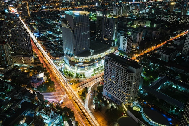 Il centro della città del quartiere degli affari di Bangkok sopra l'intersezione di Samyan e il traffico con edifici e grattacieli durante la notte