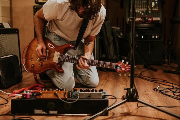 Il chitarrista della rock band esegue la ripetizione in studio di registrazione