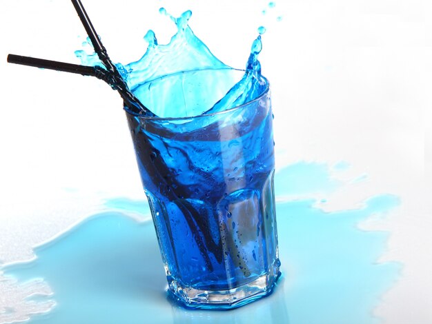 Il cocktail blu con spruzza isolato su bianco