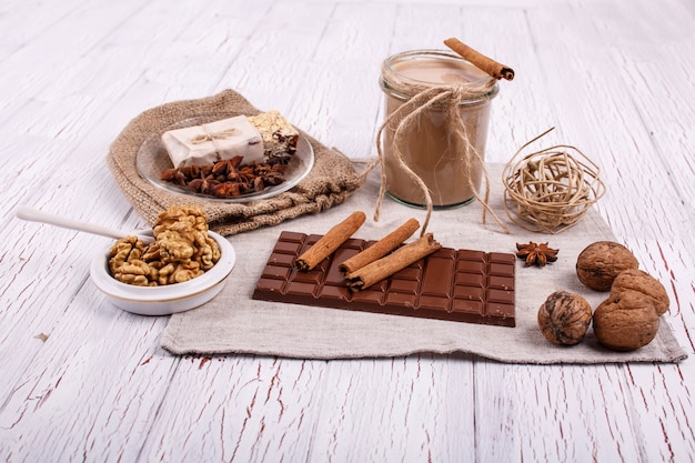 Il coctail di detox marrone con bastoncini di cannella, noci e cioccolato si trovano sul tavolo