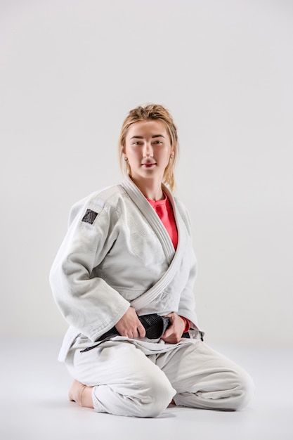 Il combattente judoka femminile in posa sul grigio