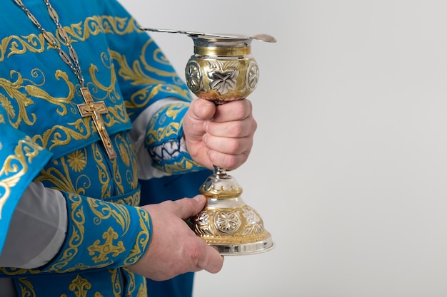 Il concetto della santa comunione con il sacerdote che tiene la coppa