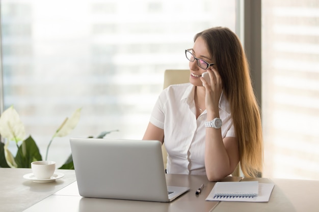 Il consulente finanziario femminile consulta i clienti per telefono