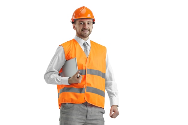 Il costruttore in un giubbotto di costruzione e un casco arancione con tablet.